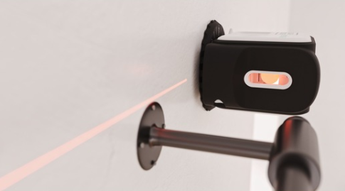 Nivel láser BLACK+DECKER REVBDLL100-XJ marcando una línea sobre pared
