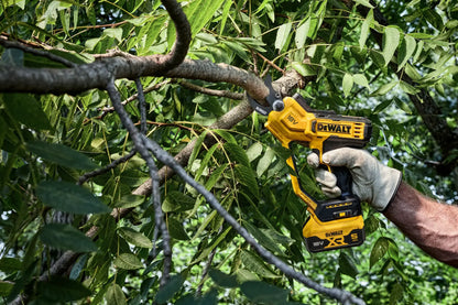 Podadora DeWalt DCMPP568 en uso cortando una rama